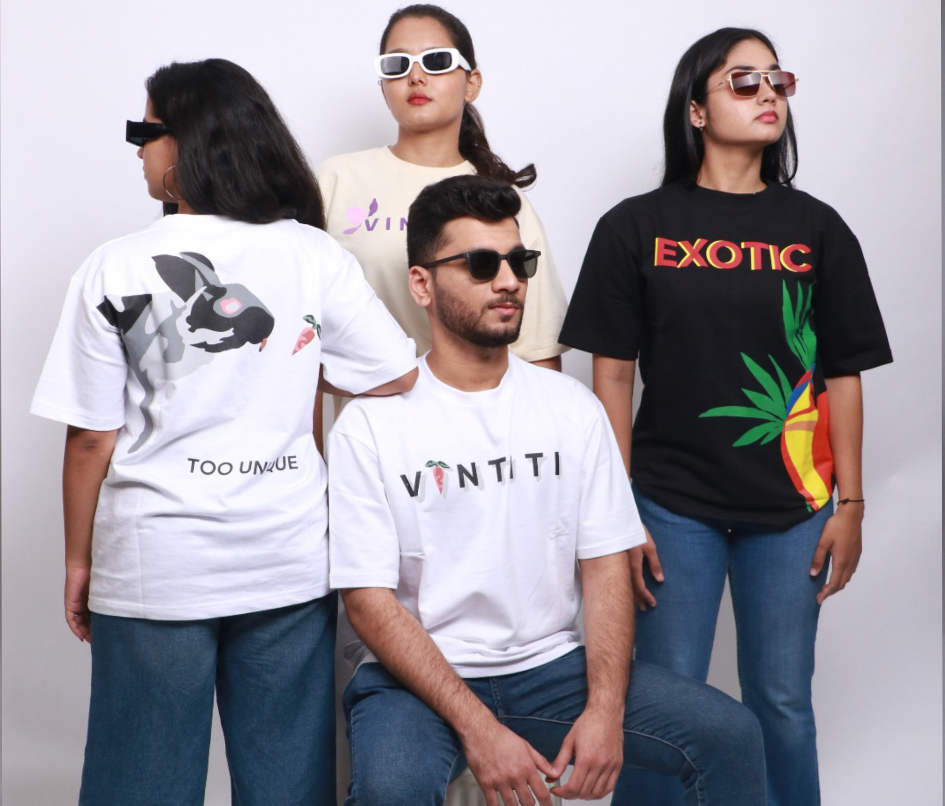 Vintiti oversized t-shirts styled by four models, showcasing 'Exotic' tropical prints, 'Too Unique' bunny design, and minimalist logo prints.